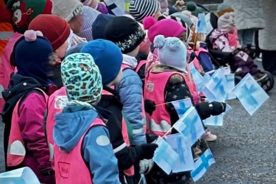 Lapsia askarreltujen Suomen lippujen kanssa.