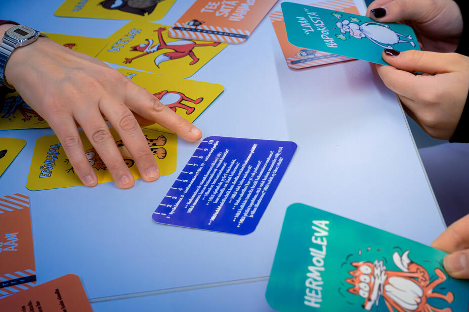 Kädet selaamassa vuorovaikutuskortteja.