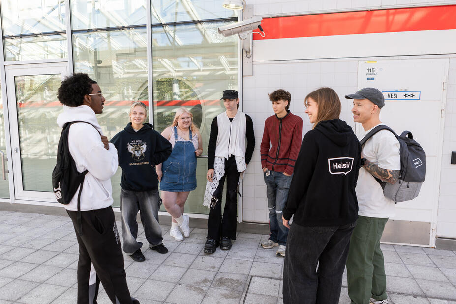 Ryhmä nuoria keskustelemassa ulkona.