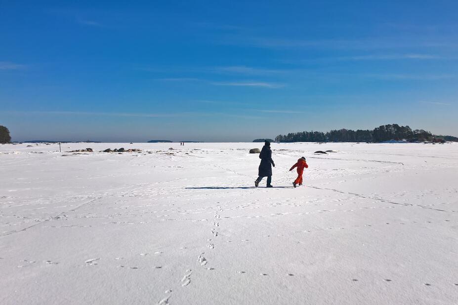 Talvisessa kuvassa ihmisiä jäällä.