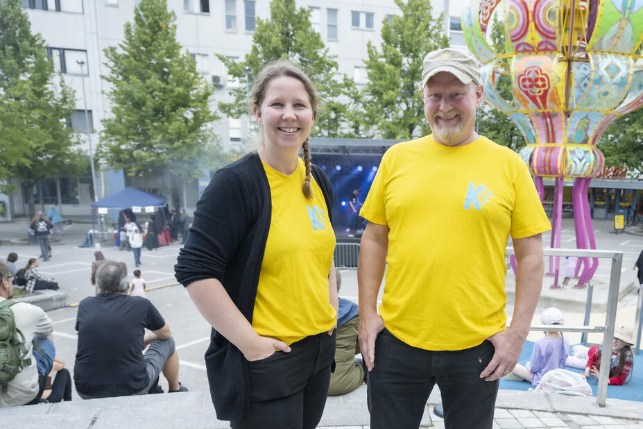 Kaksi ihmistä keltaisissa paidoissa Kannelmäen torilla