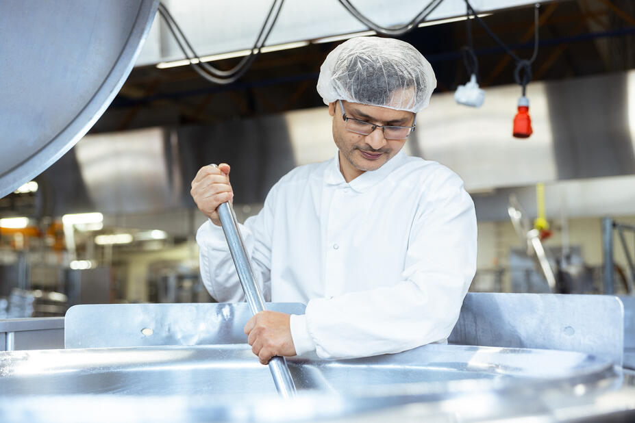 Mies sekoittaa keittoa.