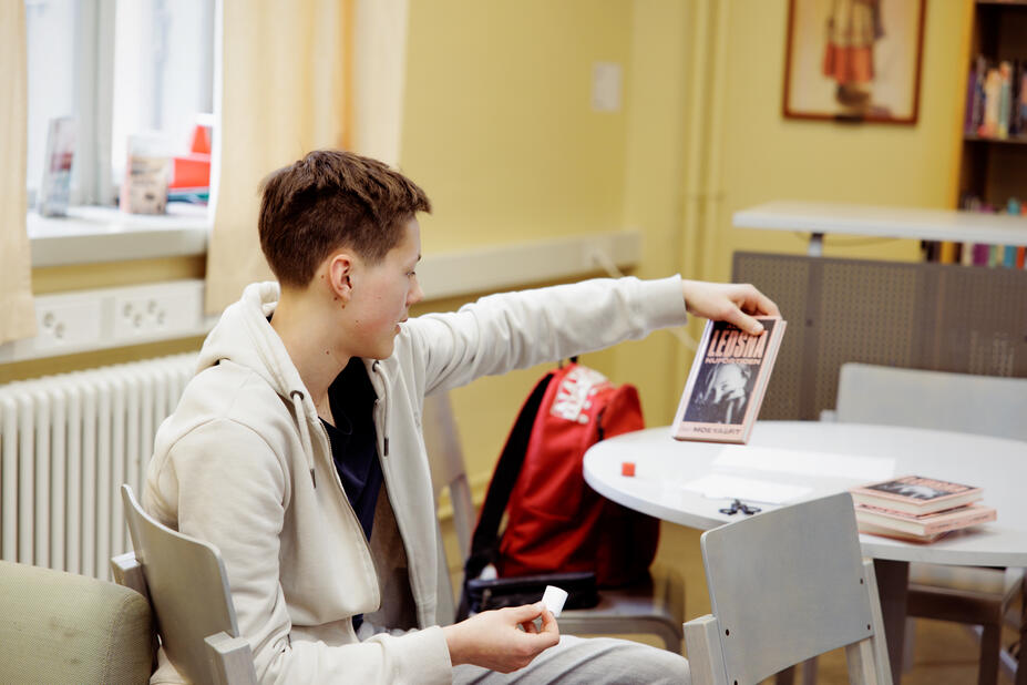 En elev tittar på pärmbilden på en bok.