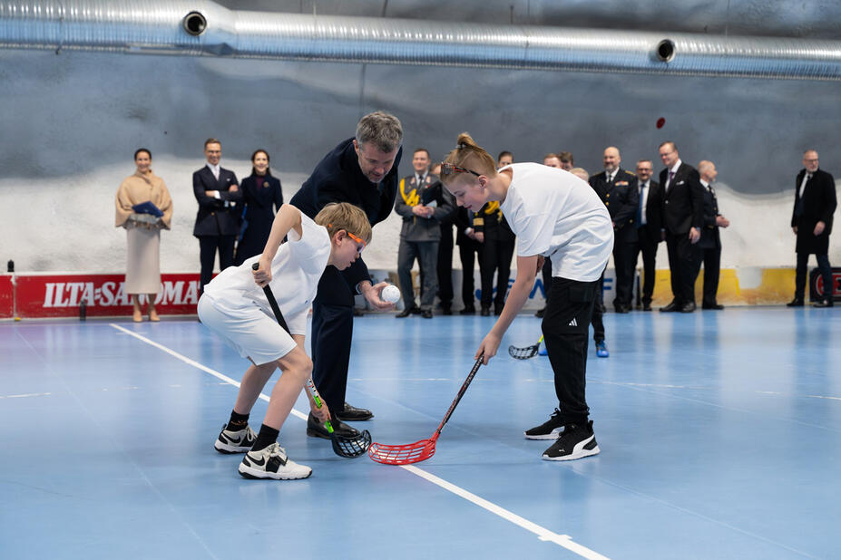 Kaksi sählynpelaajaa ja Tanskan kuningas Frederik.