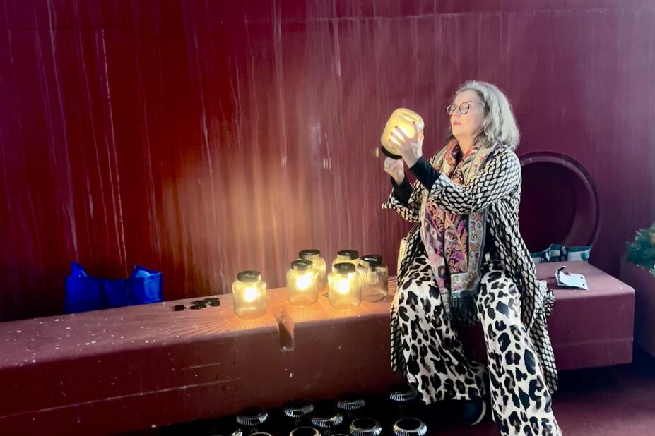 Mia Marttiini sytyttää lyhtyä.