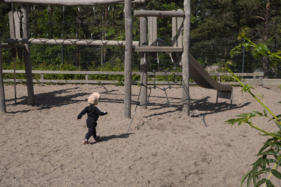Lapsi juoksee kiipeilytelinettä kohti. 
