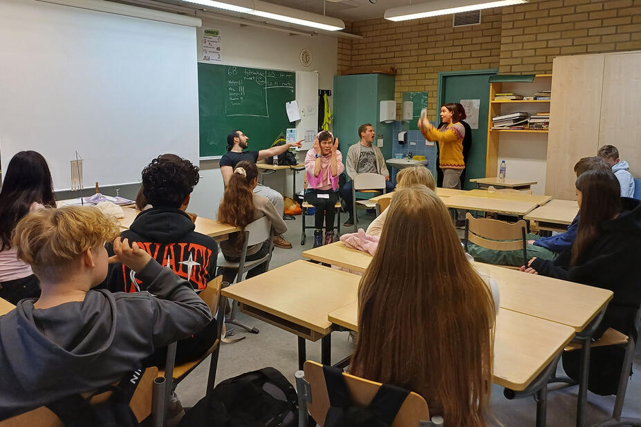 Oppilaat seuraavat esitystä luokassa.