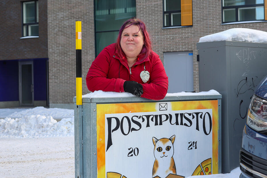 Suvi Korhonen ulkomassa nojaamassa sähkökaappiin.