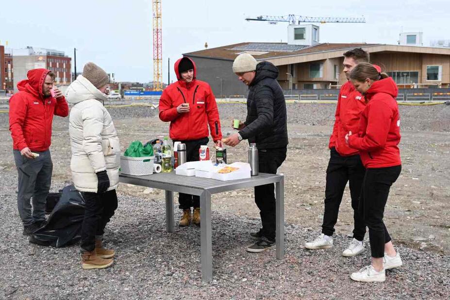 Rakennuttajia kahvittelemassa työmaan reunalla.