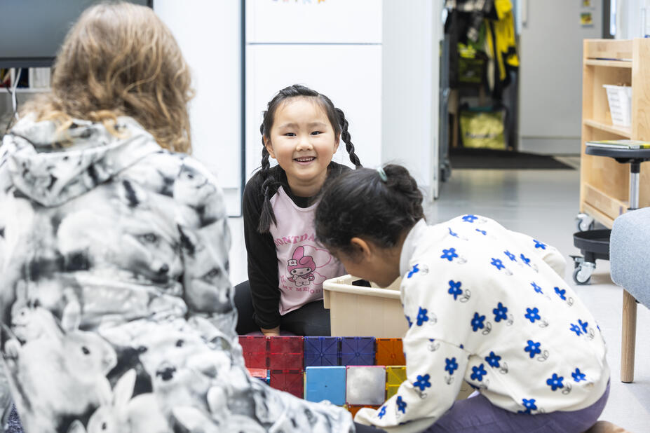 Teacher's back and two children playing