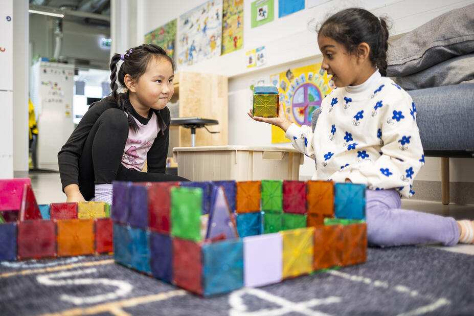 Two children playing with building blocks