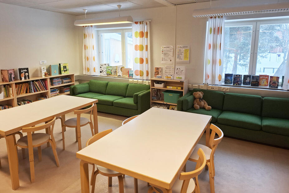 Pöytäryhmiä koulun kirjastossa.