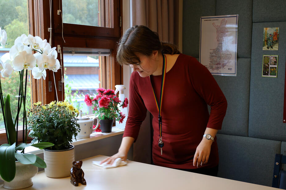 Tuuli, who is employed with wage subsidy, concentrates on wiping the table.