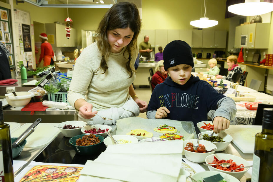 Saska, 9, ja hänen tätinsä Laura pursottavat kuorrutetta piparkakkujen päälle.
