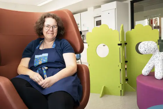 Terveydenhoitaja Johanna Koivisto istuu ruskeassa nojatuolissa Kallion perhekeskuksen perhekahvilassa.