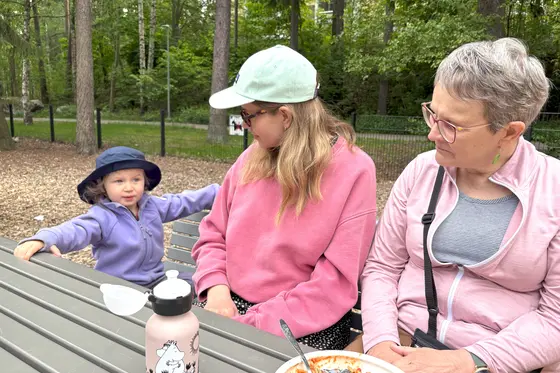 Kolme sukupolvea ruokailemassa leikkipuistossa