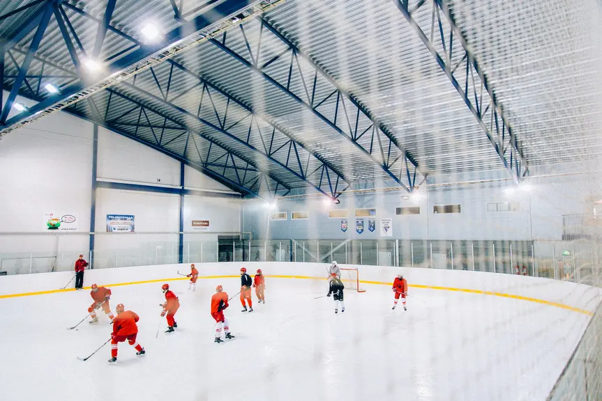 Rödklädda spelare på en hockeymatch i en ishall.