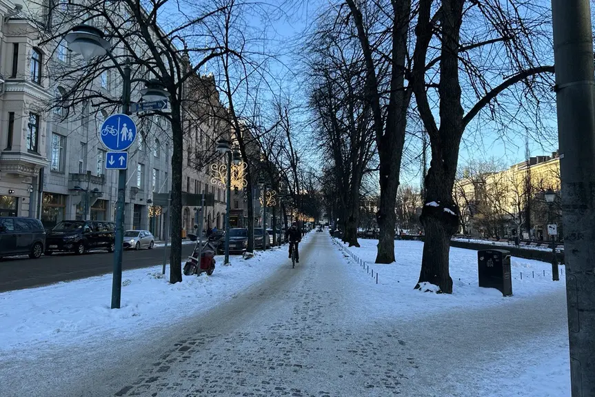 Talvinen katunäkymä ja pyöräilijä.