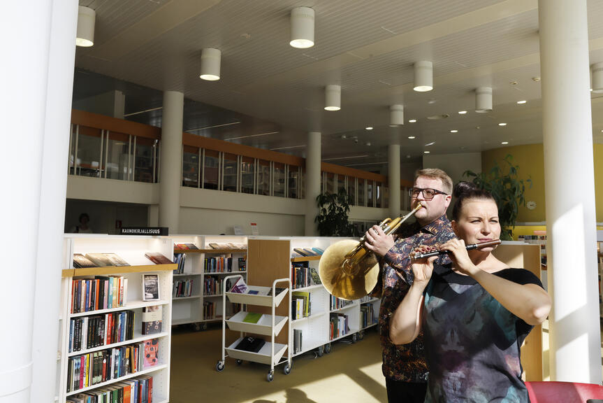 En man spelar trumpet och en kvinna spelar flöjt i Tölö bibliotek.