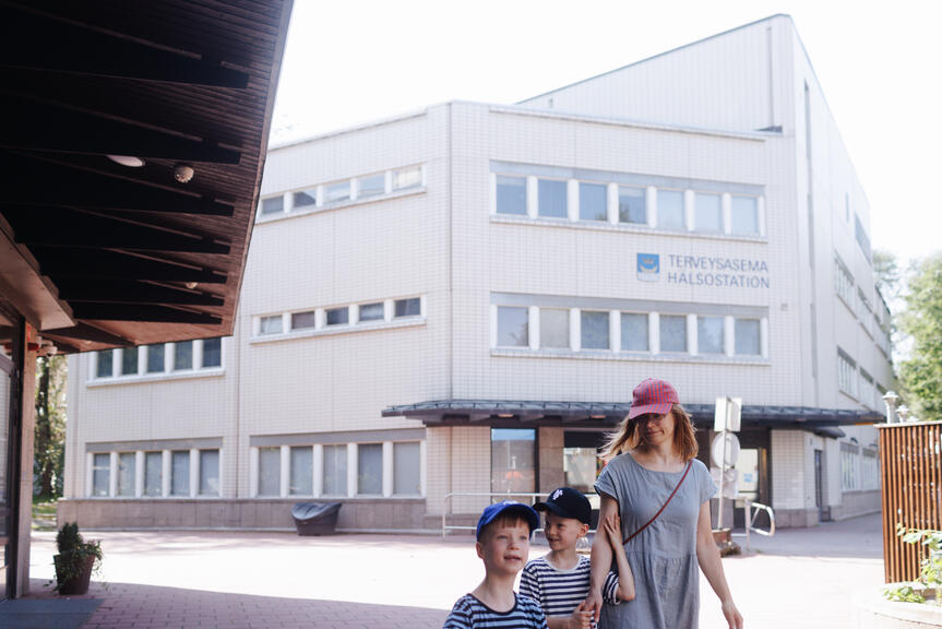 A mother and her children are walking in the health center yard.