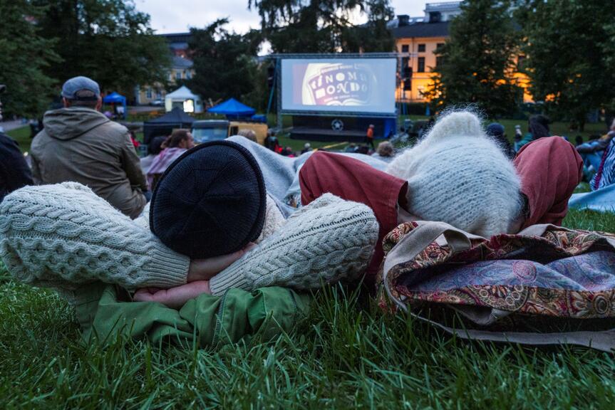Two people are watching an outdoor movie.