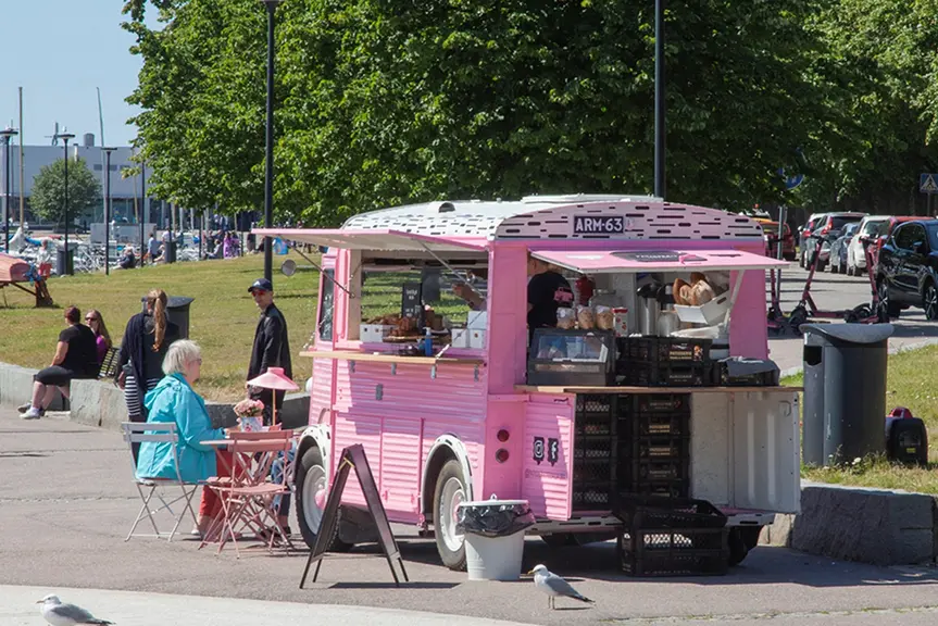 Pink food truck near a park.