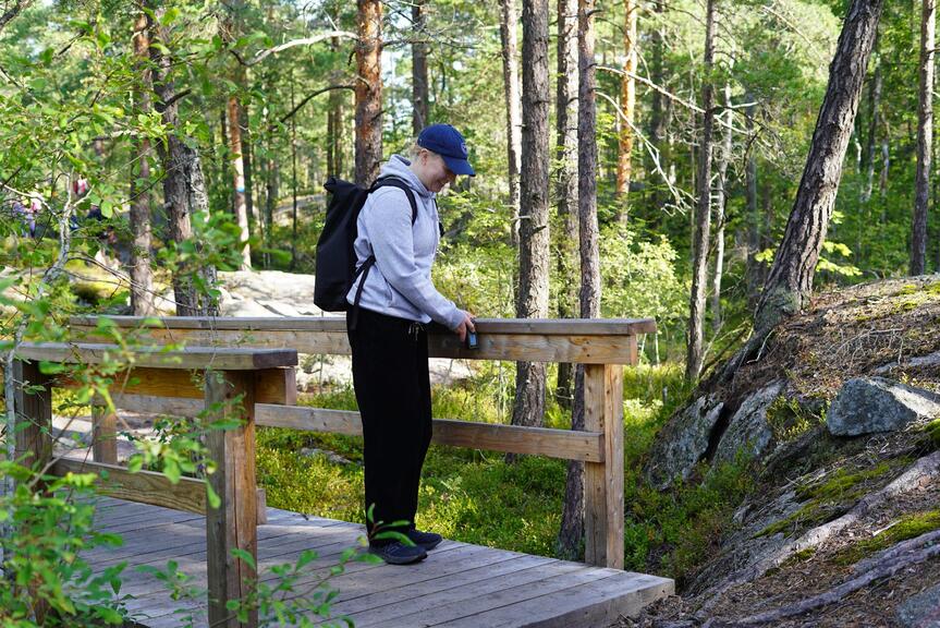 Korkeakouluharjoittelija Essi Kaila kokoamassa esteettömyystietoja luontopolulla.