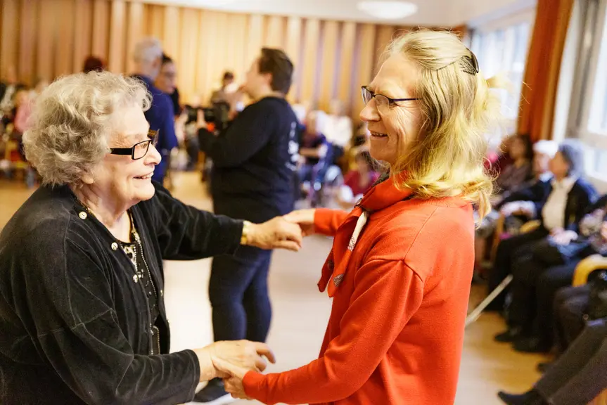 Happy people dancing in a disco for seniors.