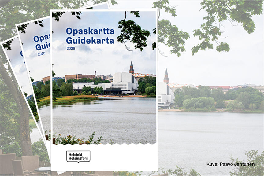 Opaskartta/Guidekarta 2026 ‑oppaan kansi. Etualalla näkyy rantaa ja vettä, taustalla kulttuurirakennus ja kaupungin siluetti puiden kehystämänä. Kannen yläosassa teksti ”Opaskartta Guidekarta 2026” ja alaosassa Helsinki–Helsingfors‑logo.
