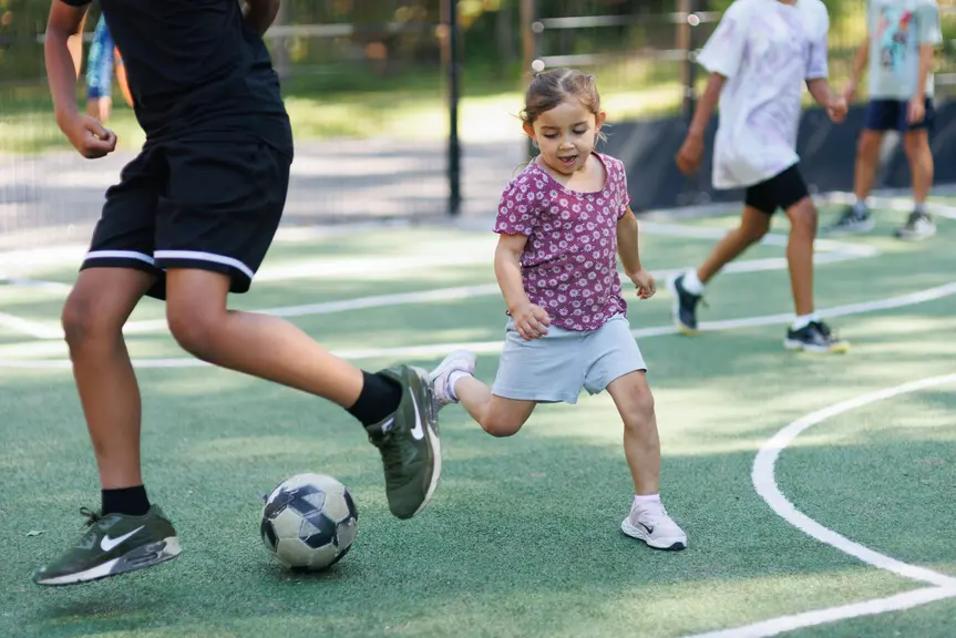 Children playing football on artificial turf.