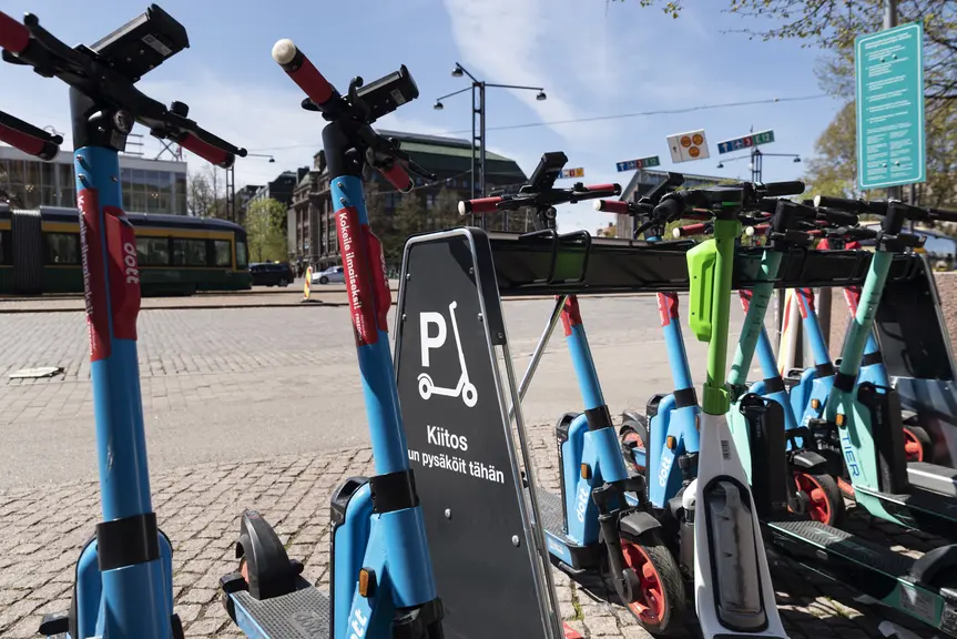 Pysäköityjä sähköpotkulautoja.