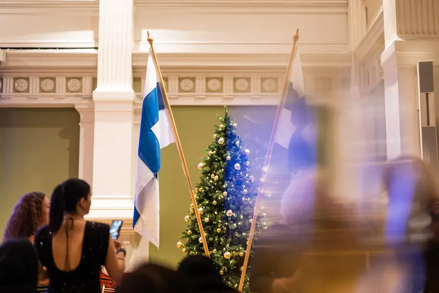 Suomen liput ja koristeltu joulukuusi kaupungintalon juhlasalissa.