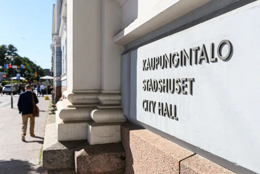 Kaupungintalon seinä. Teksti: kaupungintalo. Mies kävelee ohi.