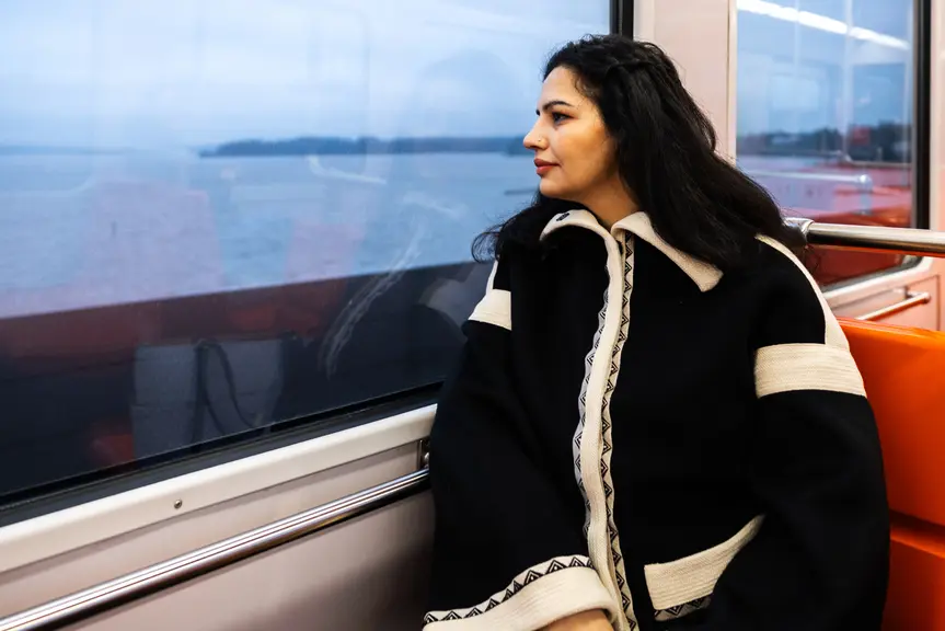 Naine vaatab metroo aknast välja.