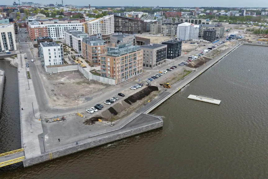 Ilmakuva Verkkosaaren pohjoisosasta Helsingissä. Rannassa näkyy uusia asuinrakennuksia, katualueita ja vielä rakentumattomia kortteleita veden äärellä.