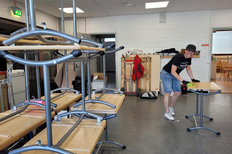 En person städar en bänk i skolan.