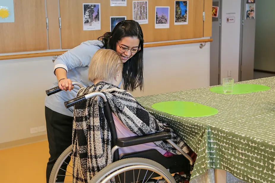 Kristine Buyose työskentelemässä seniorin kanssa.