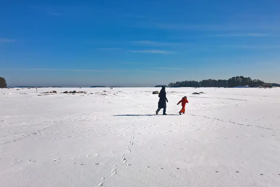 Talvisessa kuvassa ihmisiä jäällä.