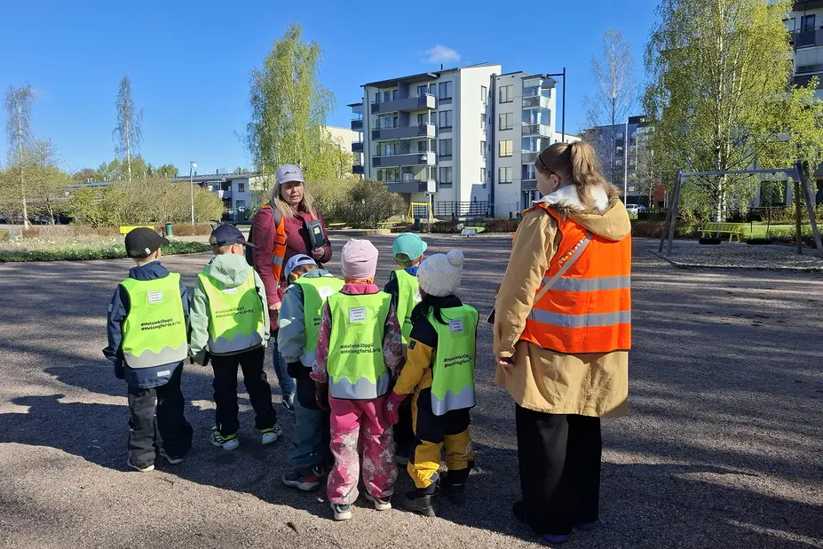 Päiväkotiryhmä puiston hiekkakentällä.