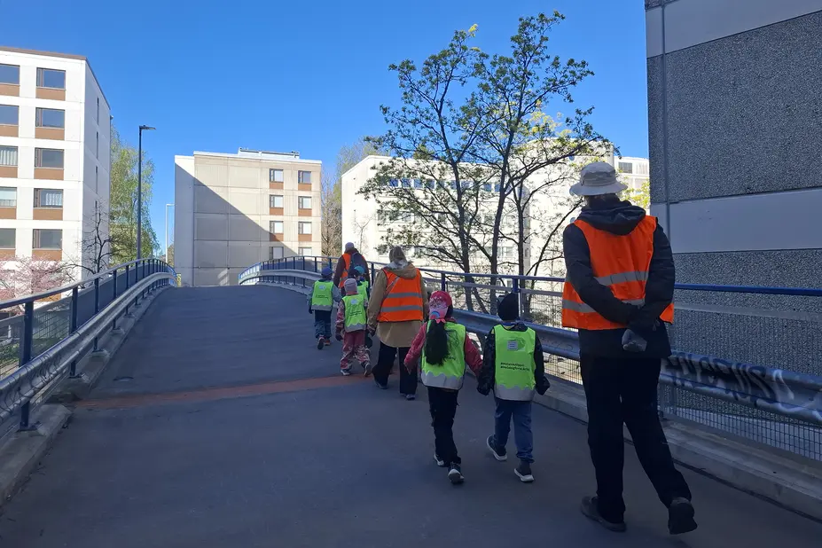 Lapset ja aikuiset ylittävät sillan.