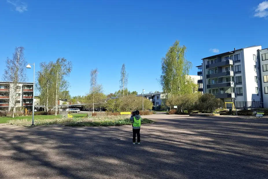 Lapsi kuvaa kukkapenkkiä puistossa.