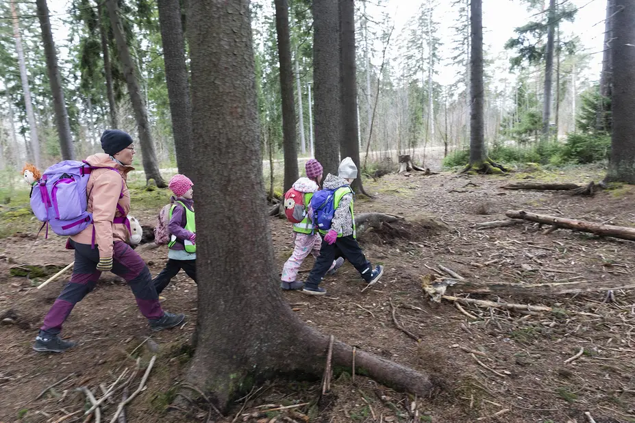 Lapset ja Eeva koskela kulkevat metsässä reput selässä