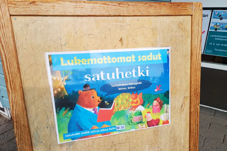 Puinen kyltti ohjaa leikkipuiston Lukemattomat sadut -tuokioon.