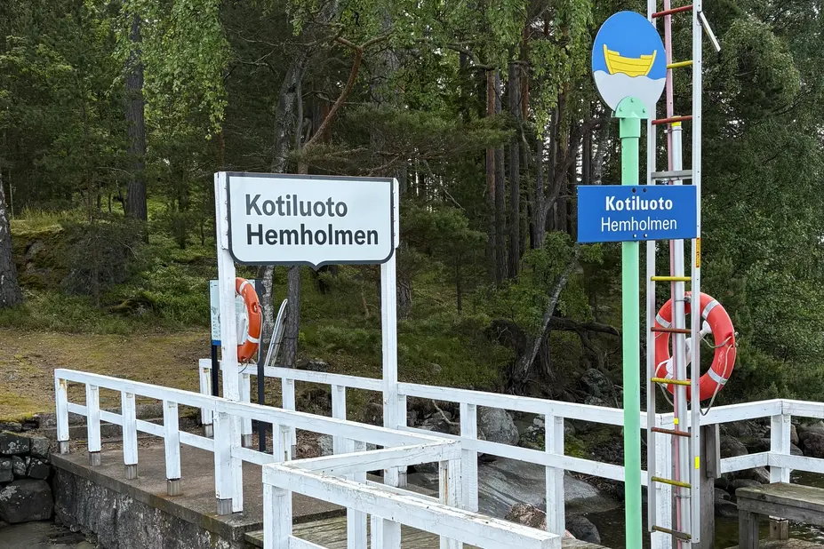 The jetty on Kotiluoto island as seen from the sea. The photo shows a sign with the text Kotiluoto inside the City of Helsinki’s framed logo.