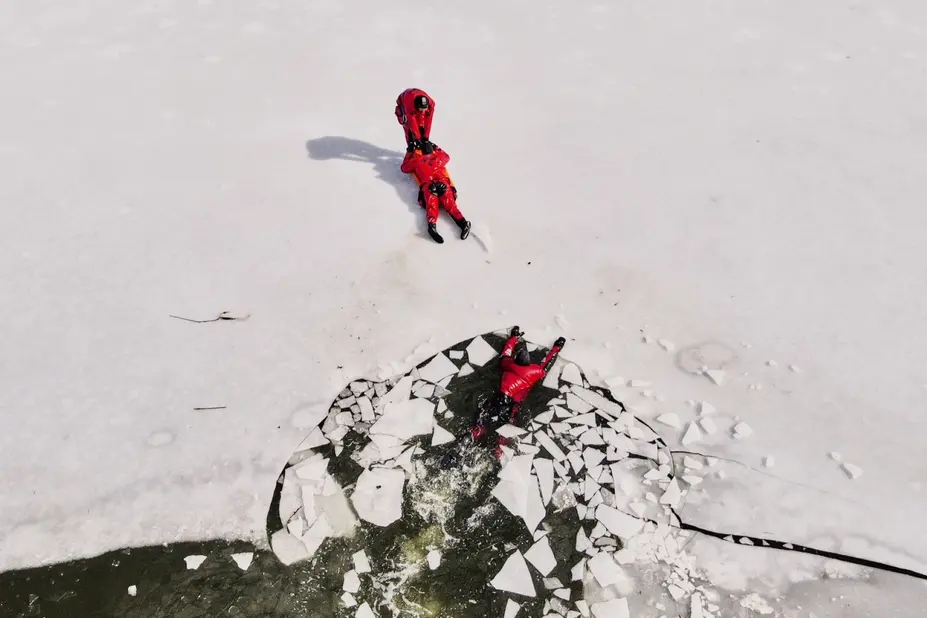Kolme pelastajaa harjoittelevat jäihin pudonneen pelastamista.