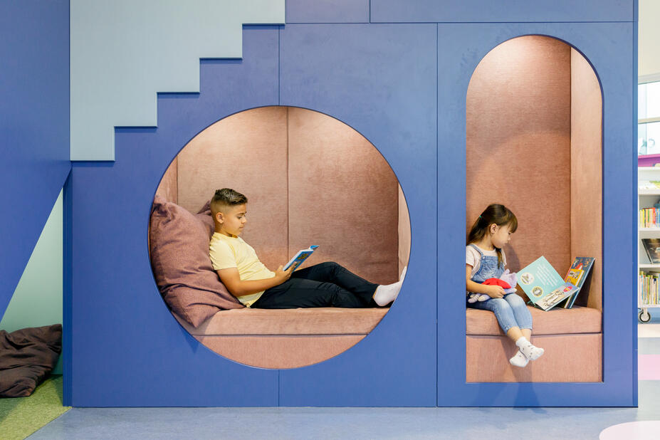 Två barn läser i läshörnen i Lillhoplax barnbibliotek.