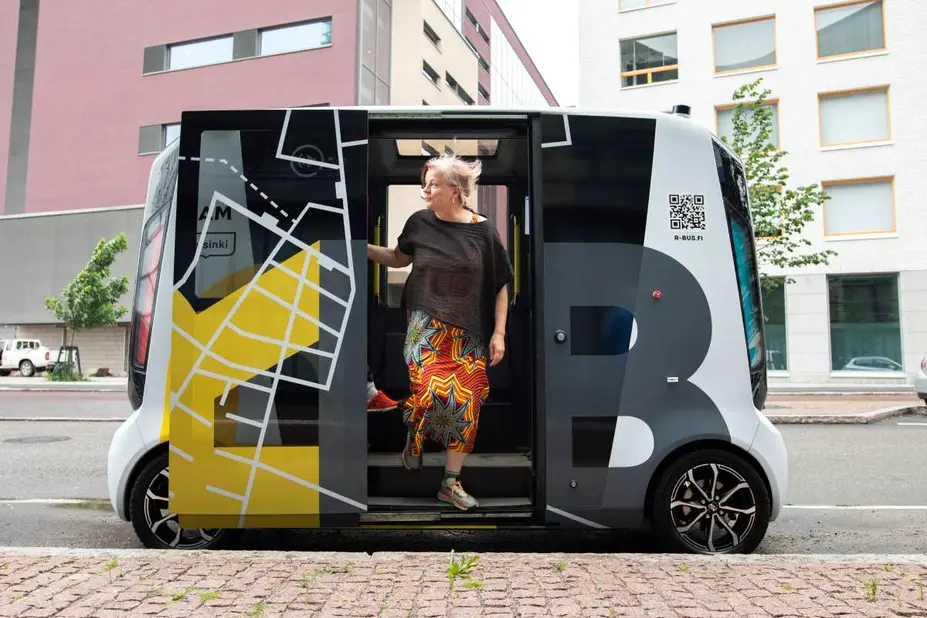 Matkustaja nousemassa ulos robottibussista. 