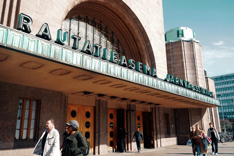 Ihmisiä kävelee Helsingin päärautatieaseman ulkopuolella. 