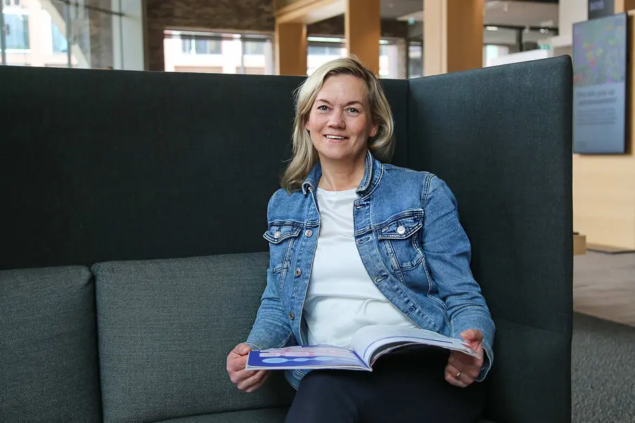 Kati Immeli-Vänskä istuu nojatuolilla toimistolla.