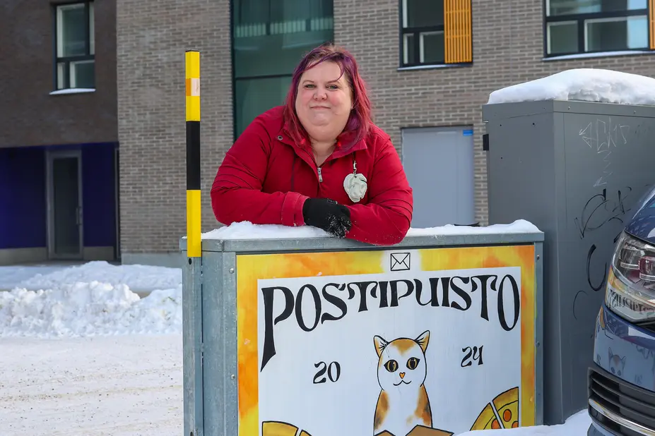 Suvi Korhonen ulkomassa nojaamassa sähkökaappiin.